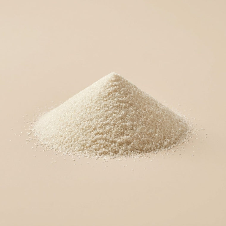 En konisk hog av fina vita korn pa beige bakgrund.